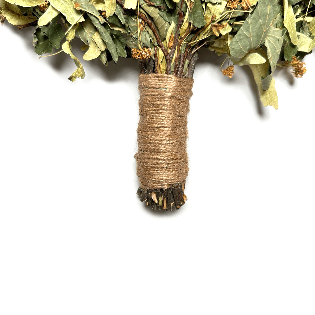 Hand holding linden sauna whisk for soft massage therapy